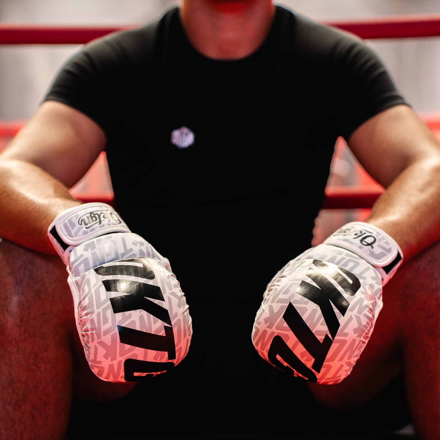 Gants MMA OKTGN blancs portés, athlète assis